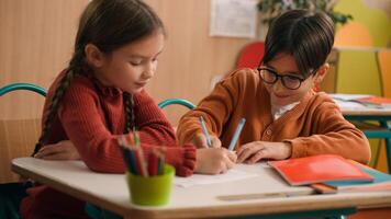 School education studying two funny playing Caucasian little girl daughter child kids children writing in classroom play game drawing fun competition class lesson boy son guy classmates friends write photo