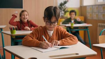 Caucasian little boy kid schoolboy nerd in glasses write task class lesson school education angry children cruel throw crumpled paper balls abuse abusing bullying classmates studying problem mock photo