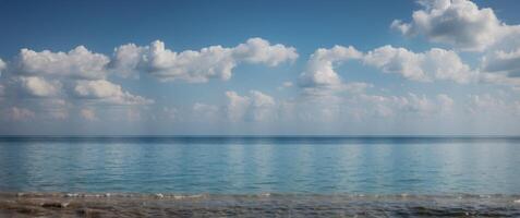 A beautiful blue ocean with a few clouds in the sky. photo