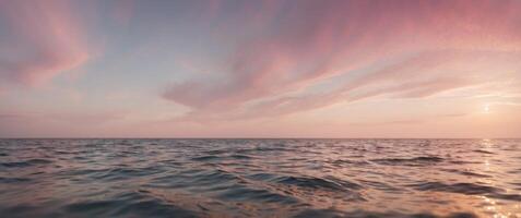 The ocean is calm and the sky is a beautiful shade of pink. photo