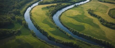 Aerial View of a Winding River Through Lush Green Fields and Forests. photo