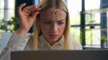 Caucasian woman businesswoman business girl take off glasses looking at laptop screen confused blurry vision after computer overwork in office eyesight problem check bad sight in eyeglasses eyestrain photo