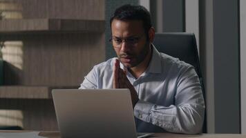 Indian man businessman American investor broker rub hands hoping wish to win lose with laptop at office feel annoyed having problems with computer angry bad result failure data loss password wrong photo
