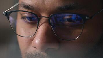 Close up businessman in eyeglasses working with computer data crypto analyzing cropped view male eyes in glasses looking at laptop monitor screen blue light reflection man business programming codding photo