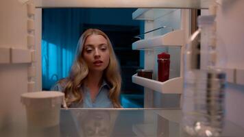 Point of view POV inside refrigerator Caucasian girl hungry woman open fridge at home kitchen look at empty shelves order food products delivery with mobile phone app online service web store shopping photo