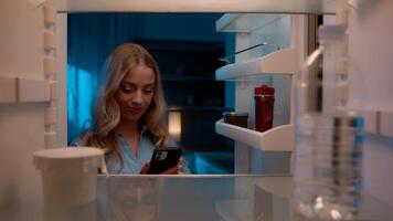Point of view POV inside refrigerator Caucasian girl hungry woman open fridge at home kitchen look at empty shelves order food products delivery with mobile phone app online service web store shopping photo