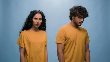 Multiracial couple diverse friends Indian man Hispanic woman quarrel argue angry conflict misunderstanding problem family trouble mad bad relationship blah-blah gesture girl in blue studio background photo