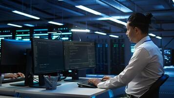 Portrait of upbeat admin in data center managing servers, operating systems and software programs. Joyous specialist in server hub ensuring networks are secure and functioning properly, camera B photo