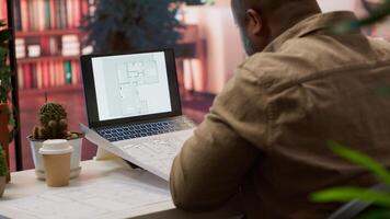 Business owner conducting strategic research on office spaces and building layouts, using blueprints and sketches to draft and organize a new creative workspace. Office hunt relocation. Camera A. photo