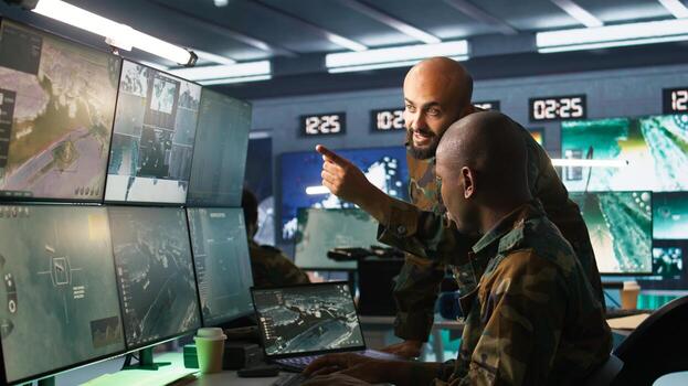 Army colleagues looking at screens in command center housing operational missile defense system designed to intercept ballistic rockets. Experts using tracking gear and radar systems, camera B photo