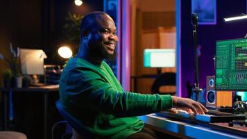 Modern producer playing piano keys to record new soundtrack, trying to produce song using midi controller electronic keyboard. Songwriter composer playing instrument notes to create tunes. Camera A. photo