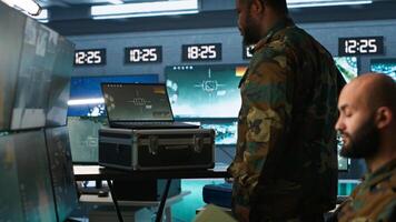 Military officer using tracking software to be able to offer info to front lines commander. Army expert doing reconnaissance to gain intel helping troops, coordinating mission activities, camera A photo
