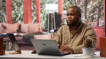 Freelancer managing startup projects and thinking about client needs from his home office, developing new growth strategy. Self employed analyst does telecommuting work on laptop. Camera A. photo