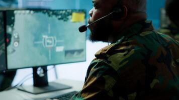 Military personnel operating in a secure office environment, processing critical information and data on big screen. Maintaining protocols essential for national defense and operations. Camera A. photo