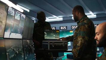 Air force officer performing tactical level surveillance in command room using laptop. Close up of military specialist in base of operations using radar on notebook to look at assault zones, camera B photo