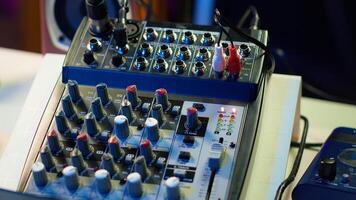 Empty home studio desk with motorized faders and pre amp knobs used with a mixing console and equalizer to produce music. Modern space with amplifier and devices for mix and master. photo