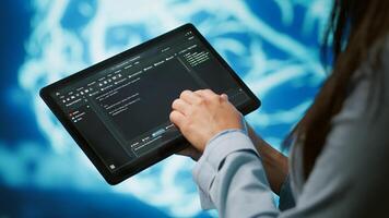 Programmer using tablet to maintenance artificial intelligence neural networks. Close up shot of computer scientist using AI system aiding in processing and transmitting information, camera A photo