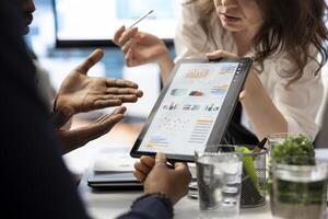 Project manager and staff engaging in a collaborative briefing meeting, using the interactive board and data visualization tools to present potential expansion solutions and tactics. Close up. photo
