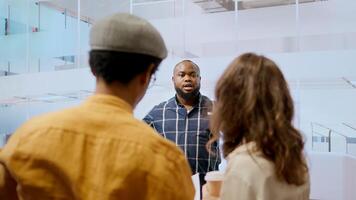 Real estate advisor discussing a promising property deal with potential corporate clients, examining blueprints and planning architectural layout of modern office space. Consider renting. Camera A. photo