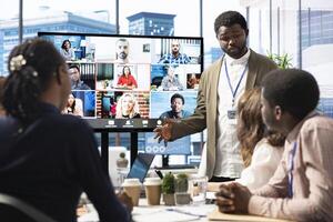 Company employees attending a meeting via videocall with investors, discussing about the future of the enterprise. Advisory board and workers examining infographics data for management. photo