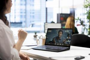 Recruiter in videoconference meeting with man after finding best talent to fill open company position. Employer hired to assess skills of candidate doing remote call in office photo