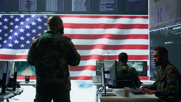 Team of military experts operates high tech computers and tablet to analyze surveillance data and manage national security operations. Working with CCTV radar satellite imagery. Camera B. photo