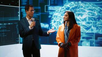 Cheerful host and expert guest talking at AI summit bringing together tech company workers, exploring latest innovations and discoveries in artificial intelligence industry, camera A photo