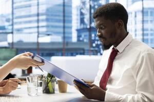 Human resources employees implementing diversity and inclusion recruitment strategy for company. Recruiters doing interview with african american man for inclusive business, offering contract photo
