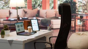 Empty modern home workstation of an entrepreneur with laptop and tablet, financial analytics data studied for startup investment and development. Remote job in business industry. photo
