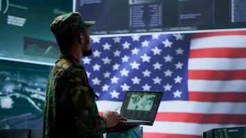 US soldiers operating in a high tech cybersecurity command post, managing state secrets and classified information. Protecting servers against digital threats and cyber warfare. Camera A. photo