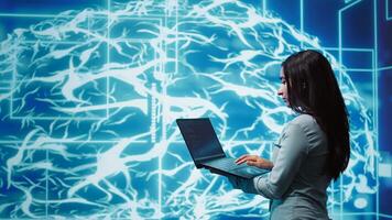 Computer scientist working on laptop, programming artificial intelligence computing simulating human brain. Woman using notebook, developing AI machine learning algorithms, camera B photo