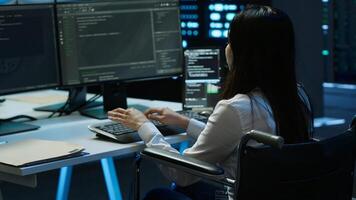 Person with paraplegia in inclusive server hub overseeing data center, making improvements. Woman in wheelchair doing tasks in data center, tracking network traffic, camera A photo