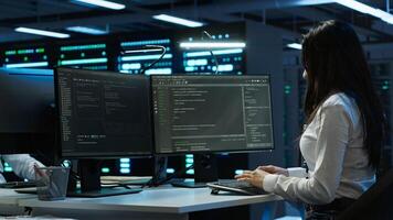Data center network engineer designing, implementing and managing infrastructure to ensure optimal performance and reliability. IT expert in server room coding on computer, camera A photo
