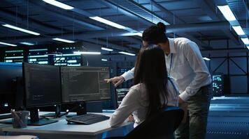 Computer scientists in data center managing and maintaining databases, ensuring data integrity and security. IT staff members updating server room systems using, camera B photo