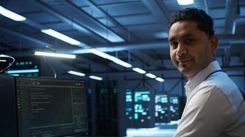 Portrait of smiling data center technician responsible for installation and repair of networking equipment solving tasks. Jolly IT expert doing maintenance on server room infrastructure, camera B photo