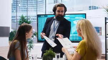 Financial advisor discussing with clients, recommending suitable financial products such as mutual funds. Agent teaching parent and daughter how to invest, offering statistical graphs, camera A photo