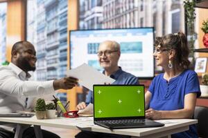 Elderly people meeting with a financial expert to develop a secure retirement plan, using a laptop with copy space screen. Search for options to protect savings and secure pension. photo