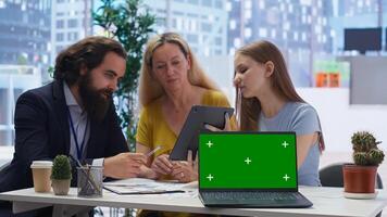 Financial adviser assisting clients in setting up investment accounts with isolated screen laptop, close up. Consultant uses financial planning software on chroma key notebook to help family, camera B photo