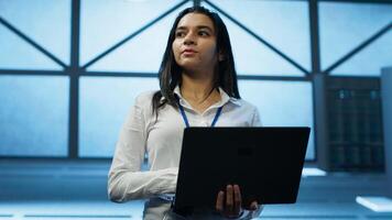 Admin in data center managing servers, operating systems and software programs. Tracking shot of woman in server hub ensuring networks are secure, up to date, and functioning properly, camera A photo