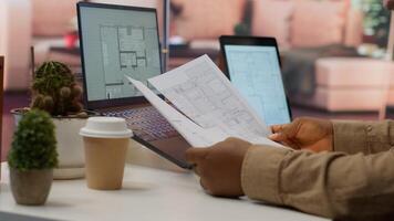 Professional entrepreneur examining blueprints and using digital tools for office space planning and development. Business owner workspace design for renting, investment strategy. Camera A. photo