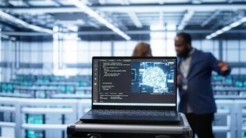 Focus on notebook used by server farm technicians in background using artificial intelligence computerized model. Close up of device with AI neural networks using pattern recognition, camera B photo