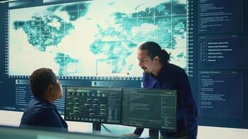 Cyber defense team working in a governmental security operations center. Experts ensuring cybercrime prevention and data breach protection, examining information on a big screen. Camera B. photo