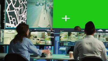 Group of employees monitoring delivery trucks routes with an isolated screen, working with satellite map and radar. Diverse people look at greenscreen display, order tracking. Camera A. photo
