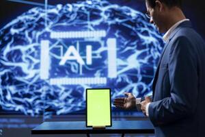 Startup employee looking over green screen tablet, using AI software to take data driven decisions. Indian man developing innovative artificial intelligence solutions for company photo