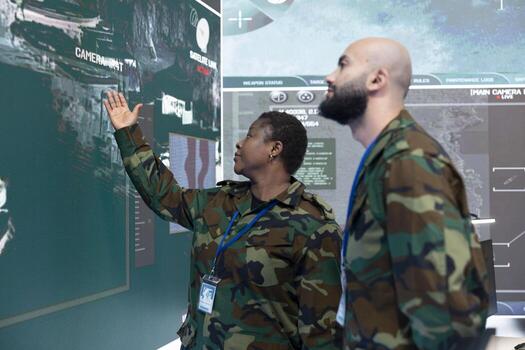 Man and woman monitoring real time information on a big screen in command center army base. Military engineers following warships trajectory in central office, support infantry unit. photo