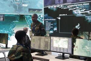 Weapons and targeting systems specialist examining surveillance footage to provide insight for a new mission, military operations. Soldier working in command center for defense. photo