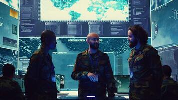 Navy operation specialists monitoring surveillance radar through a hologram, working with 3d illustrations in a military control center. Team of generals gathering intelligence. Camera B. photo