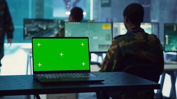 Greenscreen running on a laptop in military base command center, team of army officers monitoring coast line activity to ensure national safety. Soldiers detecting suspicious vessels. Camera A. photo