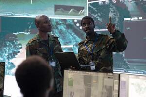 Special operation engineers work with real time battlefield data and CCTV surveillance footage in military command center. Reconnaissance specialists targeting enemy vessels on national guard radar. photo