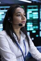 Data center call center admin responsible for providing logistics support to customers. Woman in server hub overseeing infrastructure systems and communicating with engineers photo